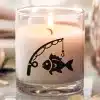 A Lit Candle In A Glass Jar With A Fish On A Fishing Line Design.