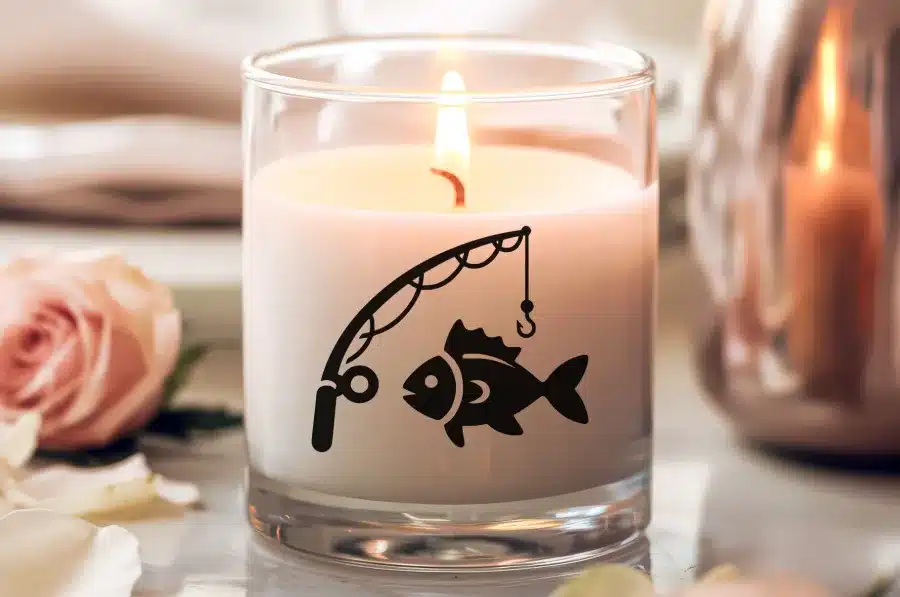 A Lit Candle In A Glass Jar With A Fish On A Fishing Line Design.