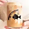 A Person Holding A Glass Of Iced Coffee With A Fishing Rod And Fish Design.