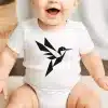A Smiling Baby Wearing A White Onesie With A Geometric Hummingbird Design.