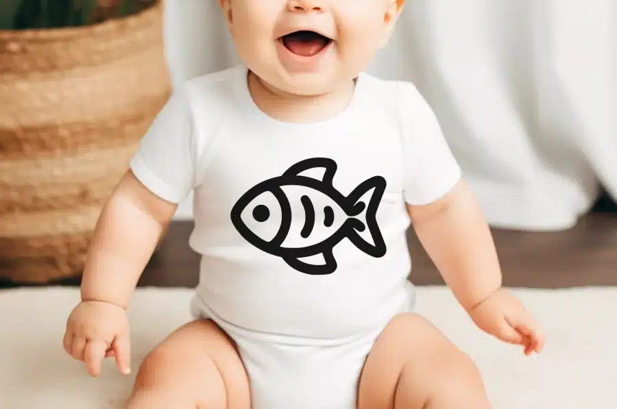 Baby Wearing A White Onesie With A Black Fish Graphic.