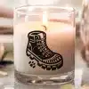 A Lit Candle With A Black Boot Graphic On Its Side.