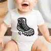 Baby Wearing A White Onesie With A Black And White Illustration Of A Hiking Boot.