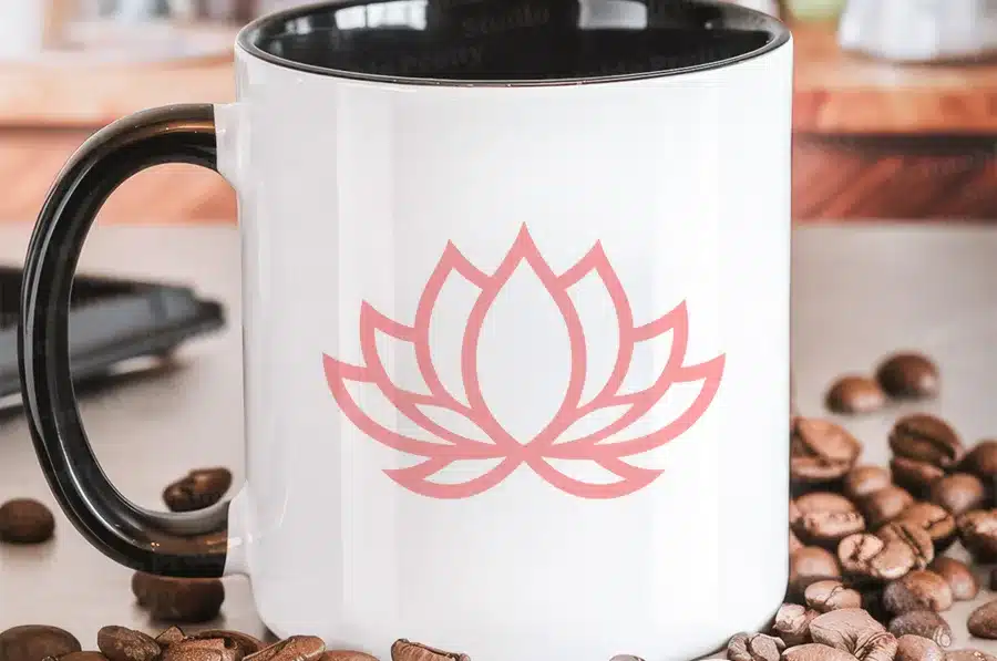 White Coffee Mug With Black Handle, Featuring A Pink Lotus Flower Design.