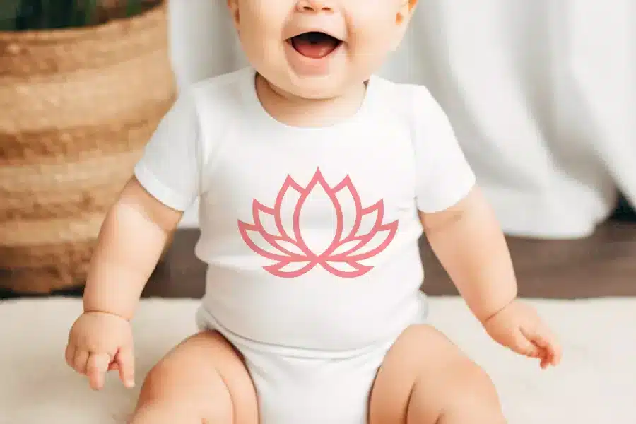 Baby Wearing A White Onesie With A Pink Lotus Flower Design.
