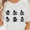 A Woman Wearing A White Shirt With Black Mushrooms On It