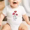 Baby Wearing A White Onesie With A Red Poppy Flower Design.
