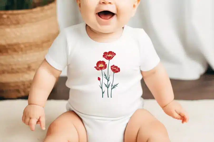 Baby Wearing A White Onesie With A Red Poppy Flower Design.