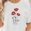 Woman Wearing A White T-Shirt With A Red Poppy Flower Design.