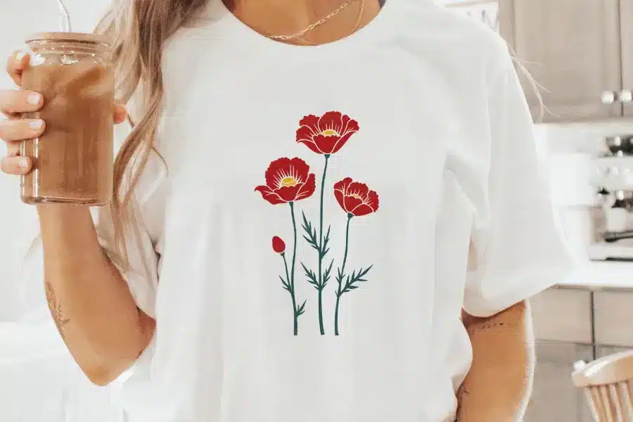 Woman Wearing A White T-Shirt With A Red Poppy Flower Design.