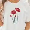 Woman Wearing A White T-Shirt With A Red Poppy Flower Design.