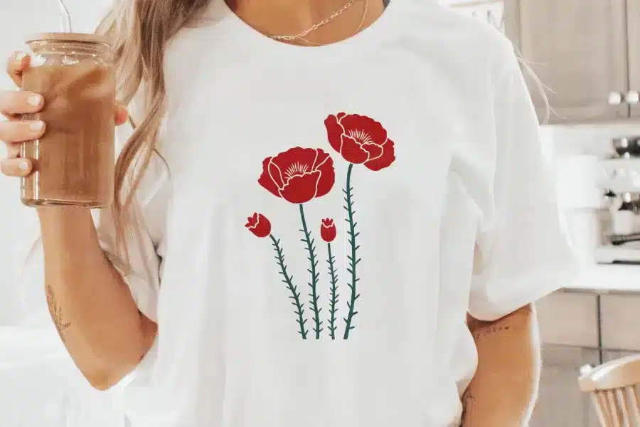 Woman Wearing A White T-Shirt With A Red Poppy Flower Design.