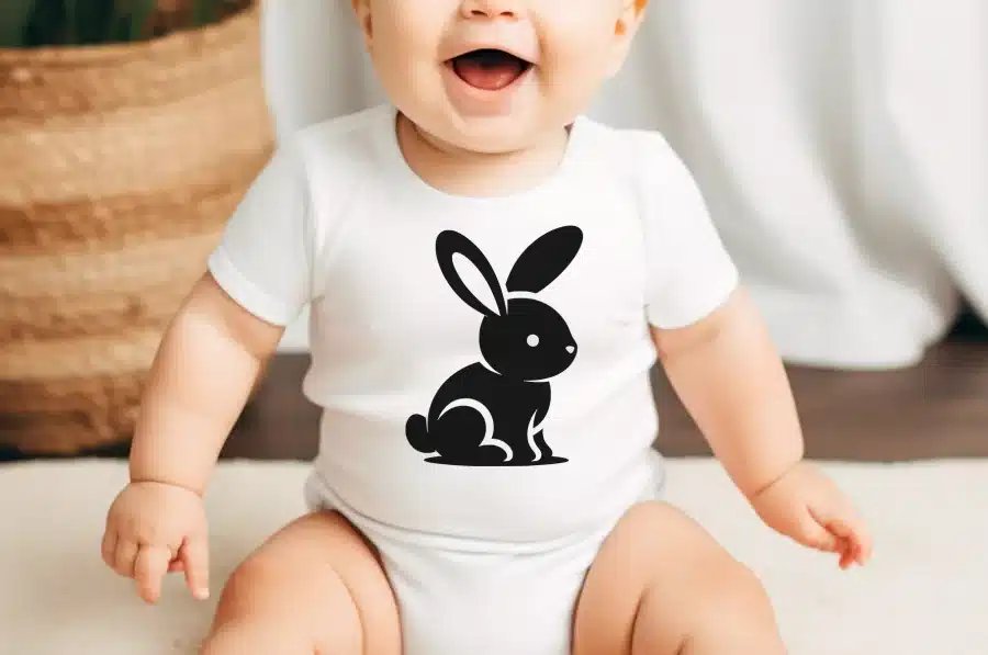 Baby Wearing A White Bodysuit With A Black Rabbit Design.