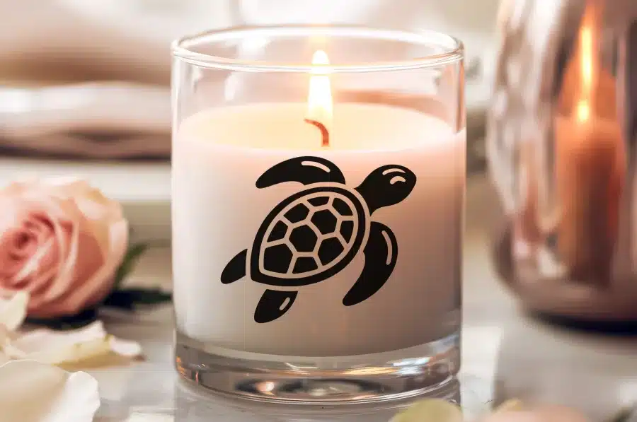 A Lit Candle With A Sea Turtle Graphic.