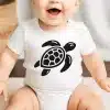 Baby Wearing A White Bodysuit With A Black Sea Turtle Graphic.