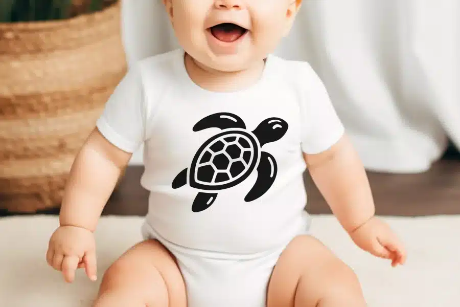 Baby wearing a white bodysuit with a black sea turtle graphic.