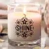 A Lit Candle In A Glass Jar With The Words Shine Bright Printed On The Side.