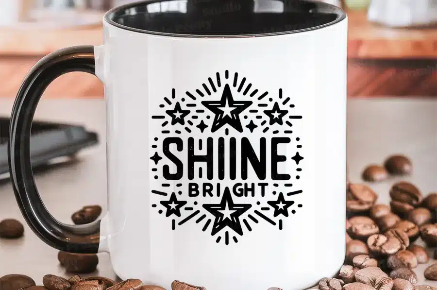 White Coffee Mug With Black Handle, Featuring A Design Of Stars And The Text Shine Bright.