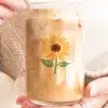 A Person'S Hands Hold A Glass Iced Coffee Can With A Sunflower Design.