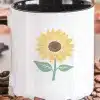 White Coffee Mug With Black Handle, Featuring A Yellow Sunflower Design.