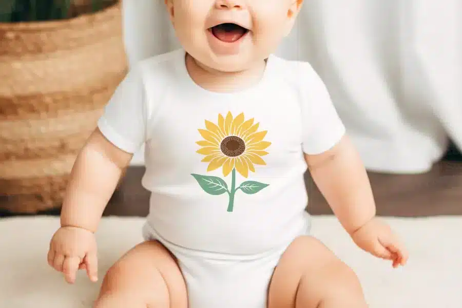 Baby Wearing A White Onesie With A Sunflower Design.