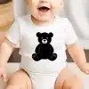 Baby Wearing A White Onesie With A Black Teddy Bear Design.