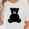 A Woman Wearing A White T-Shirt With A Black Teddy Bear Design On The Front.