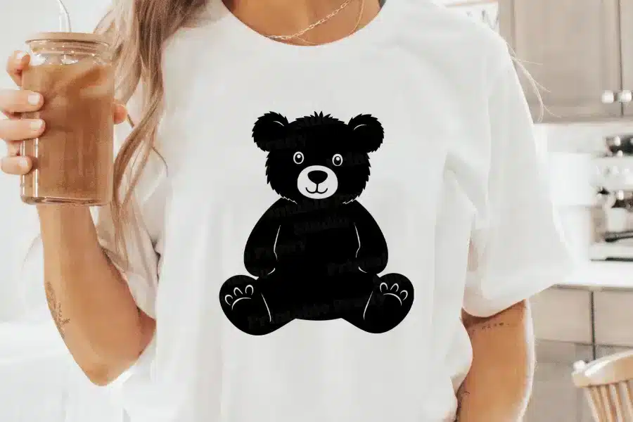 A Woman Wearing A White T-Shirt With A Black Teddy Bear Design On The Front.