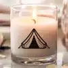 A Lit Candle In A Glass Jar With A Tent Graphic.