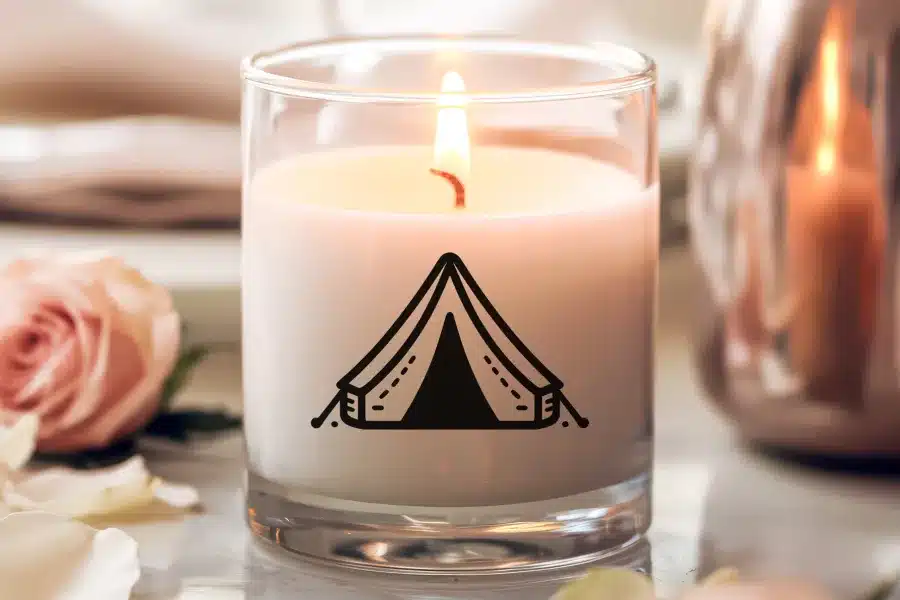 A lit candle in a glass jar with a tent graphic.