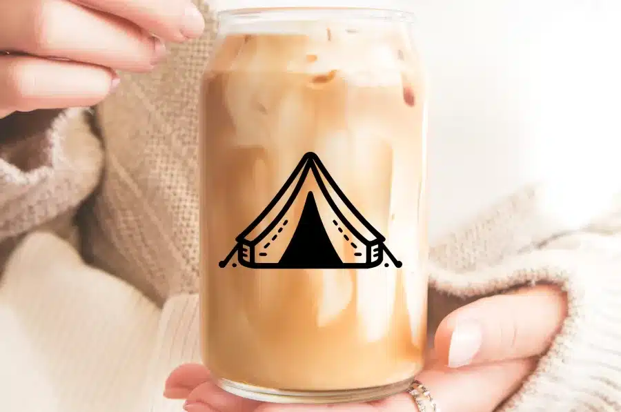 Hands Holding A Mason Jar Of Iced Coffee With A Tent Graphic.