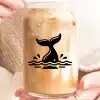A Glass Jar Of Iced Coffee With A Whale Tail Design.