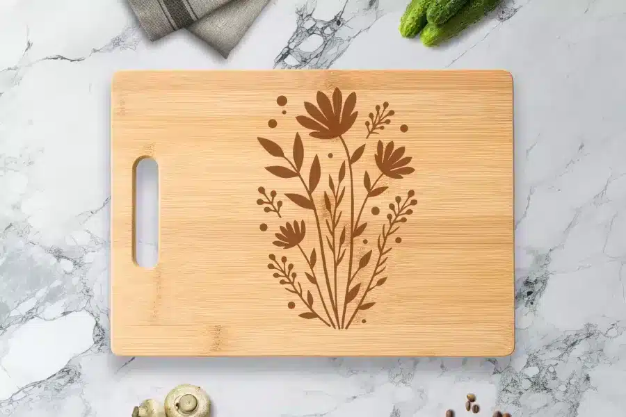 Light Brown Bamboo Cutting Board With A Dark Brown Floral Design.