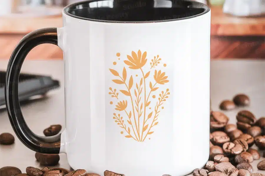White Coffee Mug With A Black Handle, Featuring A Mustard Yellow Floral Design.