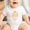 Baby Wearing A White Onesie With An Orange Floral Design.